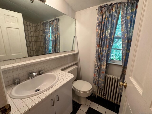 bathroom featuring tasteful backsplash, toilet, vanity, and radiator heating unit