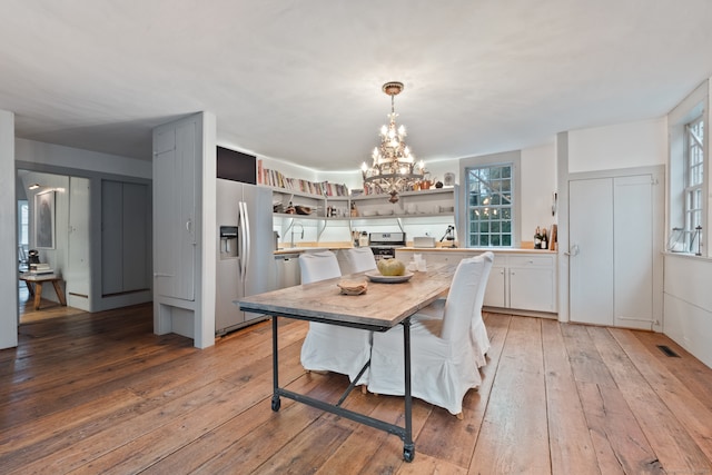 dining area with a chandelier and light hardwood / wood-style flooring