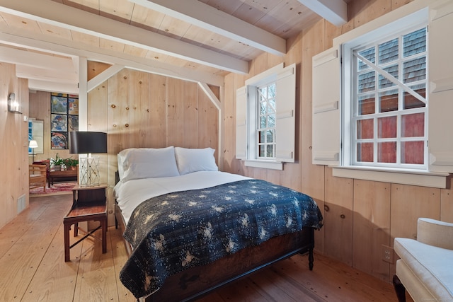 bedroom featuring beamed ceiling, wood-type flooring, wooden walls, and wooden ceiling