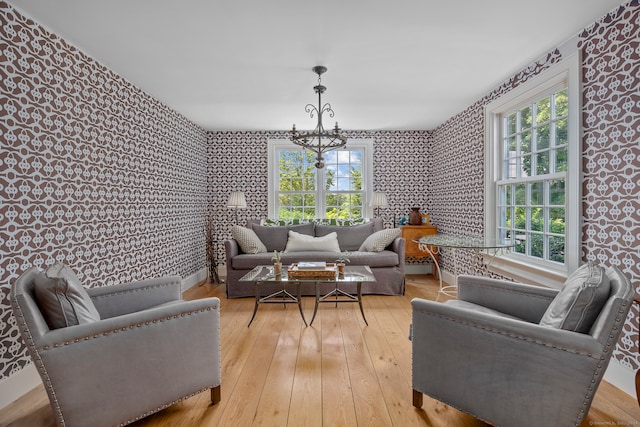 living area with light wood-type flooring and an inviting chandelier