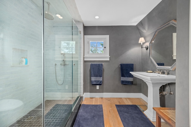 bathroom with hardwood / wood-style flooring and a shower with shower door