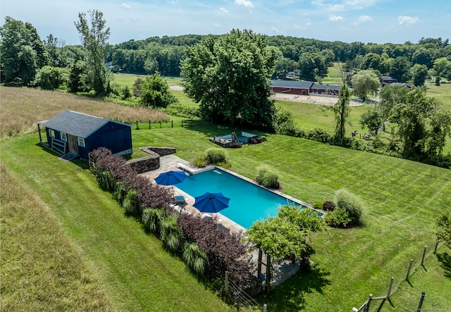 view of pool featuring a lawn and a rural view