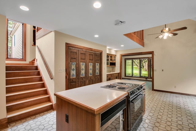 kitchen with a center island, ceiling fan, and electric stove