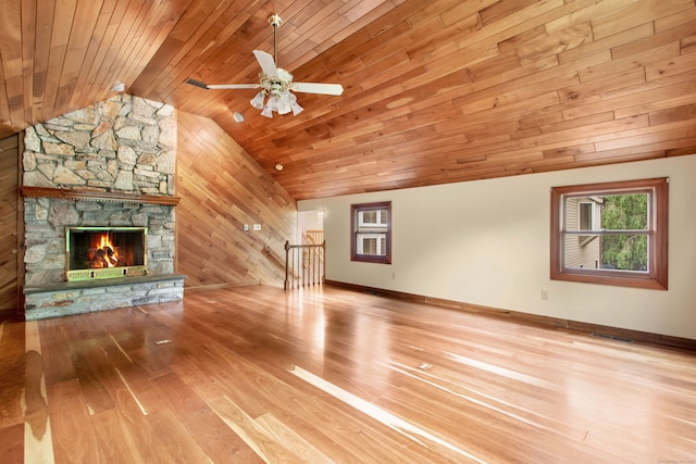 unfurnished living room with lofted ceiling, wood walls, wooden ceiling, hardwood / wood-style flooring, and a fireplace