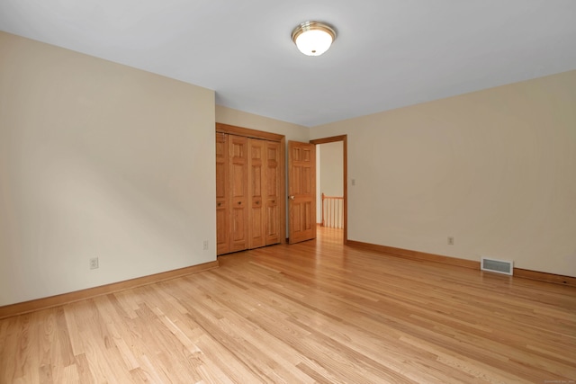 unfurnished bedroom featuring light hardwood / wood-style flooring and a closet