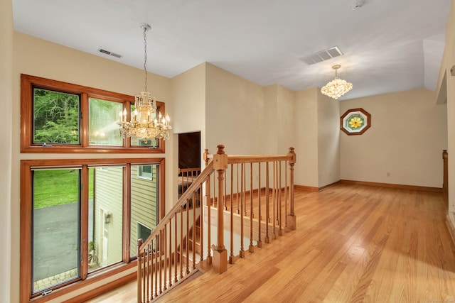 stairway featuring hardwood / wood-style floors and a notable chandelier