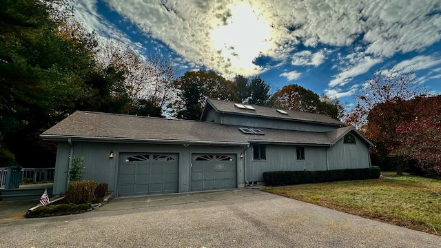 view of side of property featuring a garage and a yard