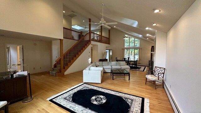 162 Pequot Trl, Stonington, CT 06379 - living area with high vaulted ceiling, ceiling fan, a baseboard heating unit, stairway, and wood finished floors