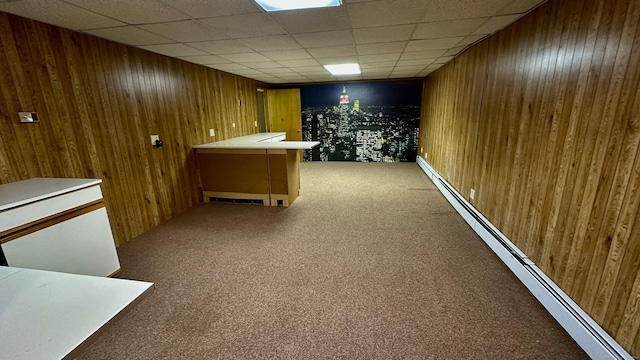 interior space with a baseboard heating unit, carpet, and wood walls