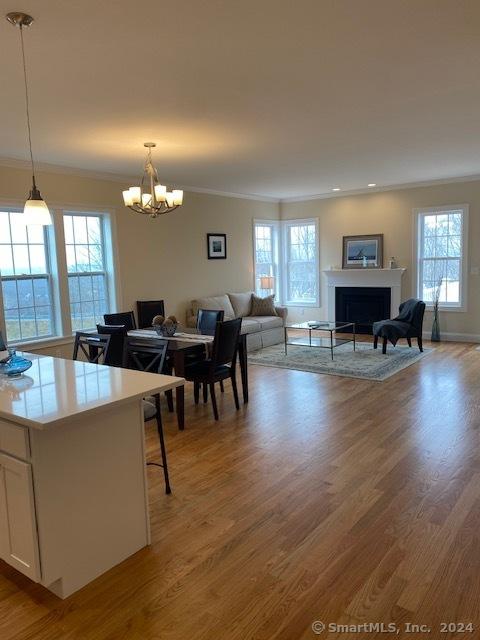 dining space featuring an inviting chandelier, hardwood / wood-style floors, and crown molding