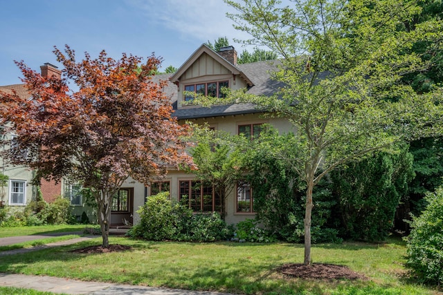 view of property hidden behind natural elements featuring a front lawn