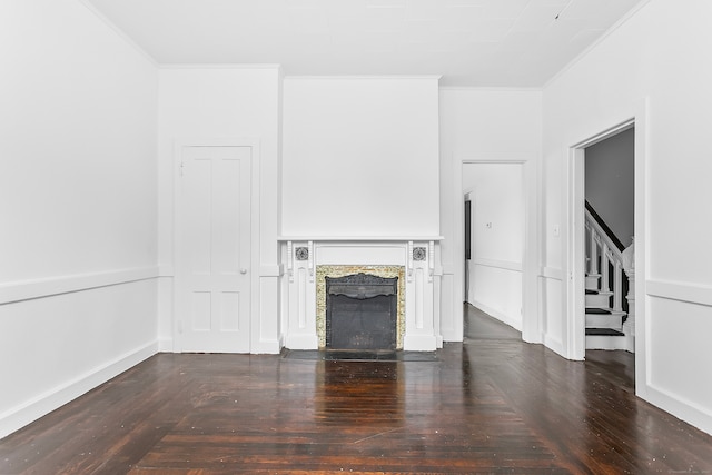 unfurnished living room featuring ornamental molding, a premium fireplace, and wood-type flooring