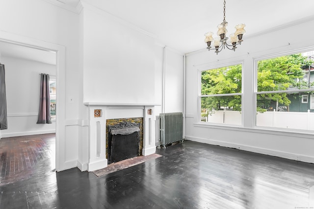 unfurnished living room featuring dark hardwood / wood-style floors, radiator, crown molding, and a notable chandelier