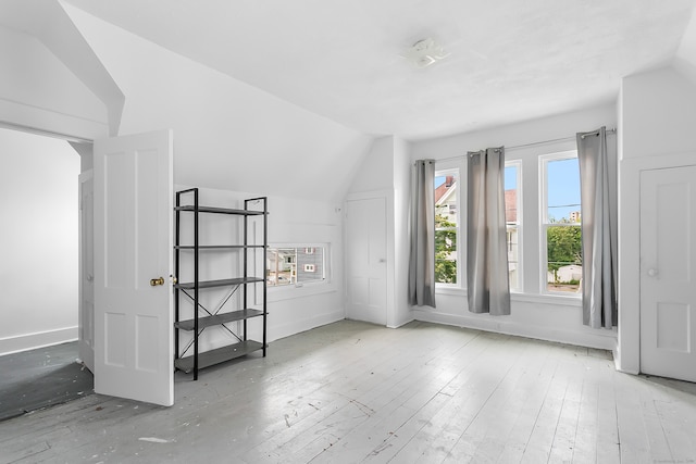 additional living space with vaulted ceiling and light wood-type flooring