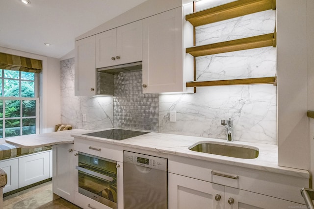 kitchen featuring tasteful backsplash, stainless steel appliances, sink, white cabinetry, and range hood