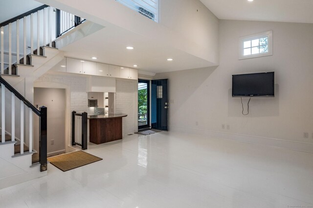 living room featuring high vaulted ceiling and light tile patterned floors