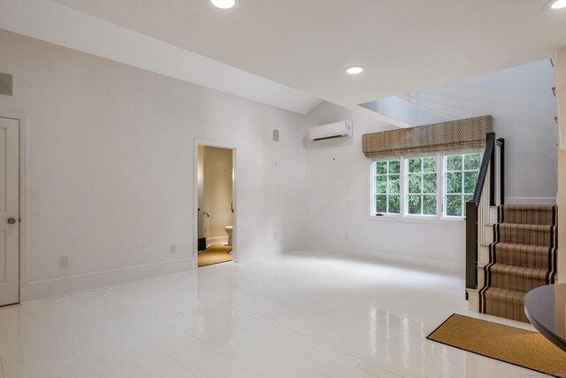 interior space featuring vaulted ceiling and a wall unit AC