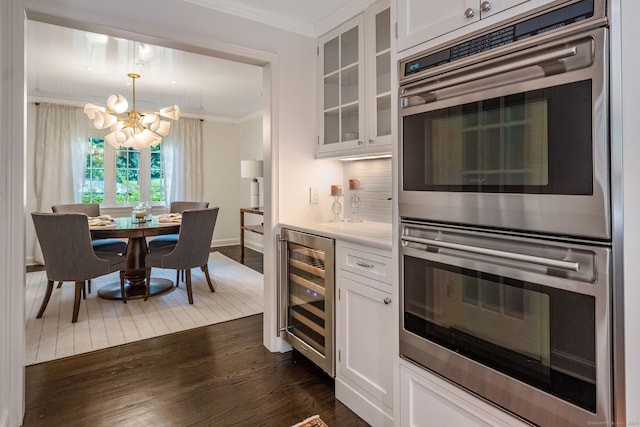 kitchen featuring white cabinetry, stainless steel double oven, dark hardwood / wood-style flooring, wine cooler, and a notable chandelier