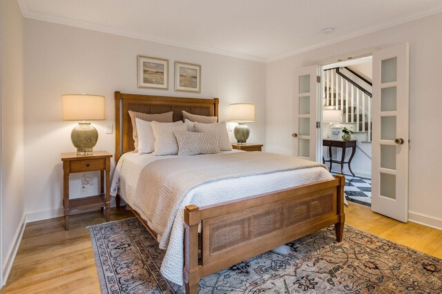 bedroom featuring crown molding and light wood-type flooring