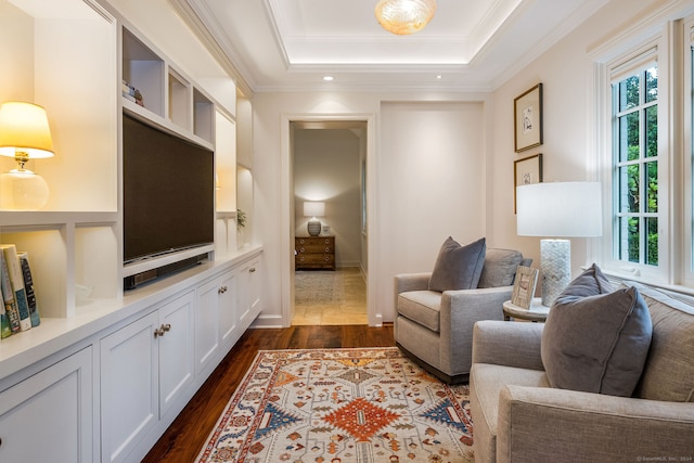 living room with ornamental molding, dark hardwood / wood-style flooring, a wealth of natural light, and a tray ceiling