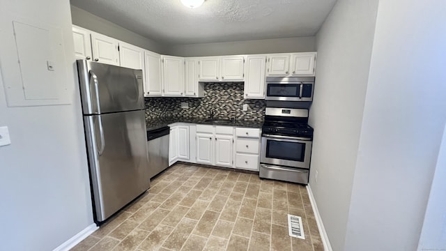 kitchen featuring white cabinets, electric panel, stainless steel appliances, and sink