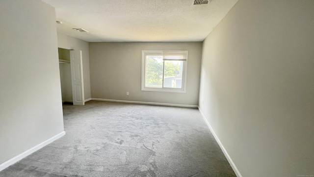 unfurnished bedroom featuring light carpet and a textured ceiling