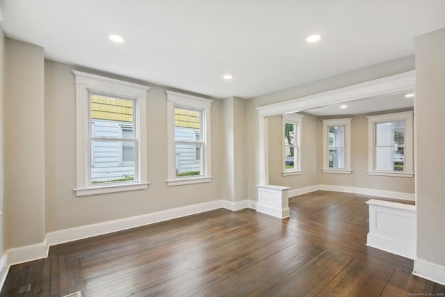 spare room with dark hardwood / wood-style floors and a healthy amount of sunlight