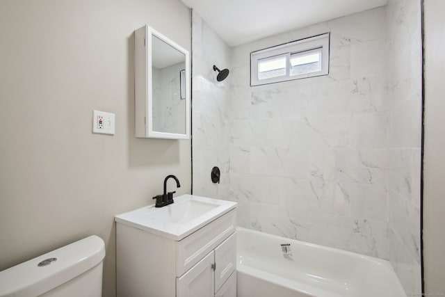 full bathroom featuring vanity, tiled shower / bath combo, and toilet