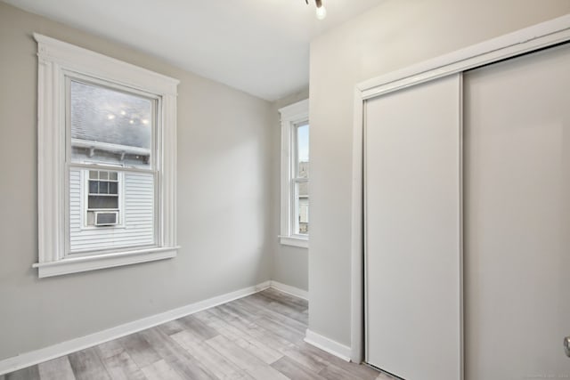 unfurnished bedroom featuring light wood-type flooring and a closet