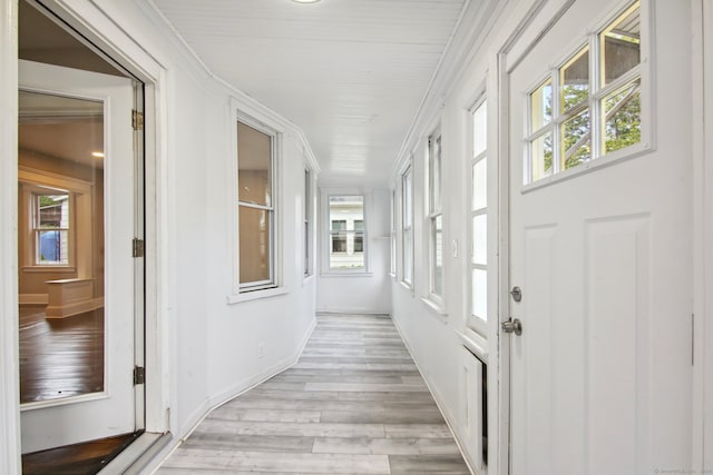 corridor featuring ornamental molding and light hardwood / wood-style floors