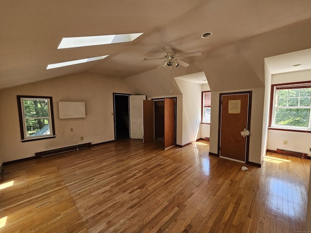 additional living space featuring a baseboard heating unit, ceiling fan, lofted ceiling, and light hardwood / wood-style floors