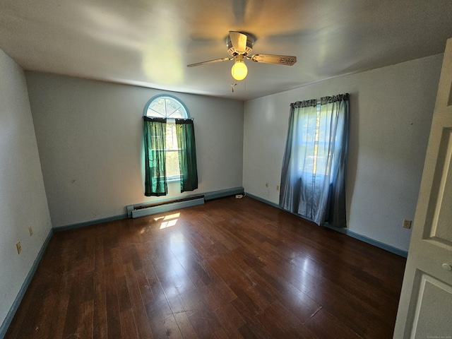 empty room featuring ceiling fan, baseboard heating, and dark wood-type flooring