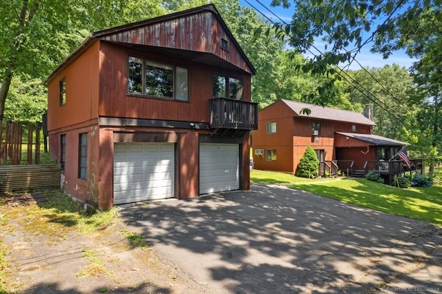 view of front property with a front yard, a garage, and a balcony