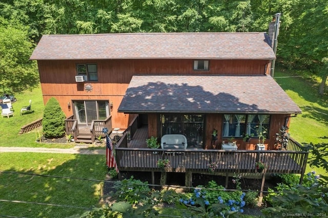 rear view of property featuring a deck, cooling unit, and a yard