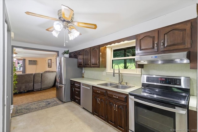 kitchen featuring stainless steel appliances, sink, a wall unit AC, ceiling fan, and dark brown cabinets