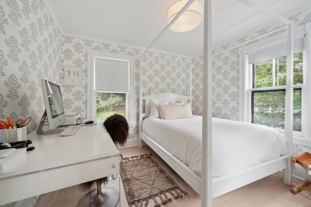 bedroom featuring crown molding and wallpapered walls
