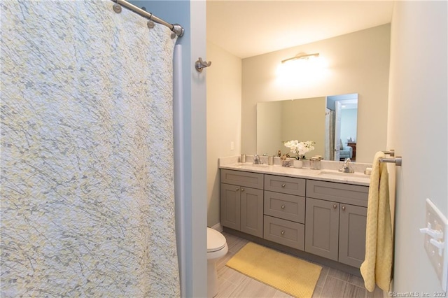 bathroom featuring vanity, walk in shower, and toilet