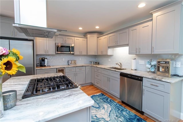 kitchen with sink, decorative backsplash, light stone countertops, and appliances with stainless steel finishes