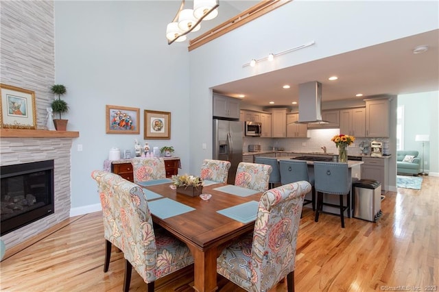 dining area featuring a tiled fireplace and light hardwood / wood-style floors