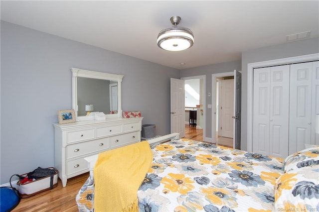 bedroom with light hardwood / wood-style floors and a closet