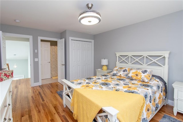 bedroom with light hardwood / wood-style flooring and a closet