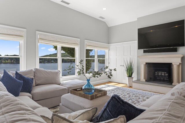 living room featuring plenty of natural light, vaulted ceiling, and light hardwood / wood-style floors