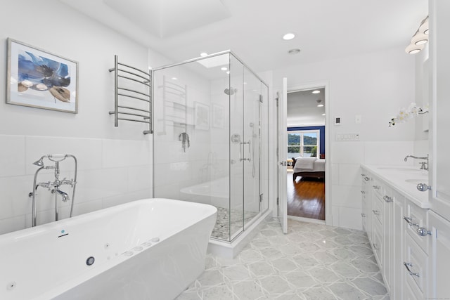 bathroom with vanity, tile walls, wood-type flooring, and separate shower and tub