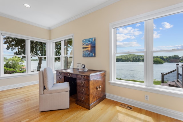 office space with a water view, crown molding, and light hardwood / wood-style floors