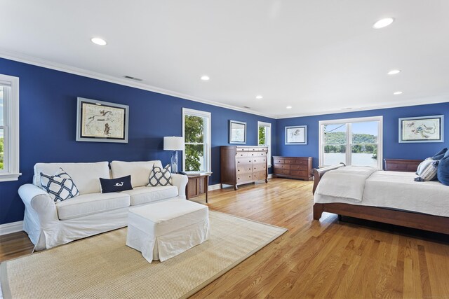 bedroom with crown molding and light wood-type flooring