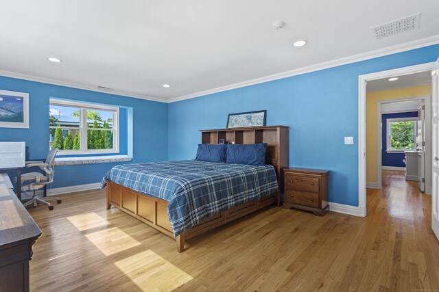 bedroom with light hardwood / wood-style floors and crown molding