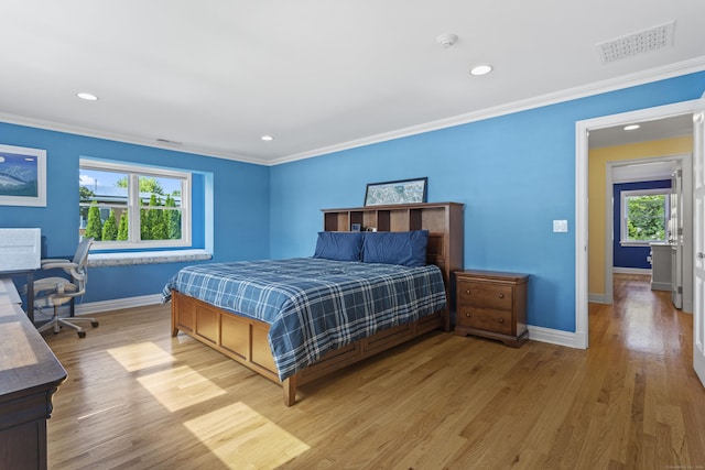 bedroom with crown molding, multiple windows, and light hardwood / wood-style flooring