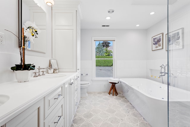 bathroom featuring double vanity, tile patterned floors, toilet, and a bathing tub