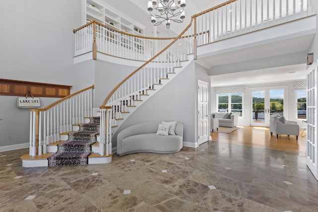 stairs with a high ceiling, a chandelier, and french doors