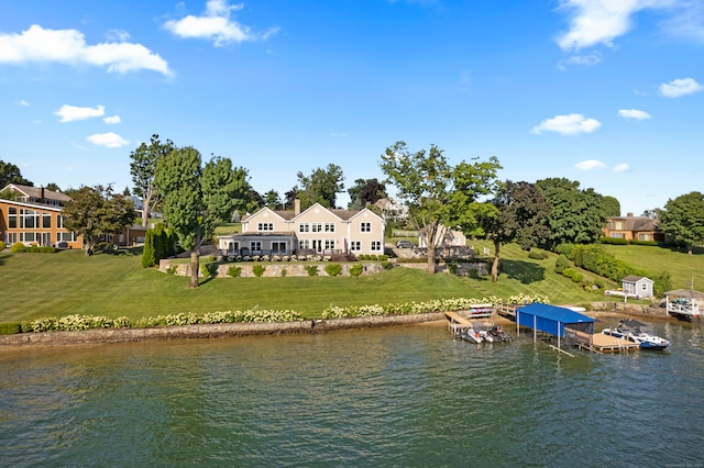 view of dock with a water view and a lawn